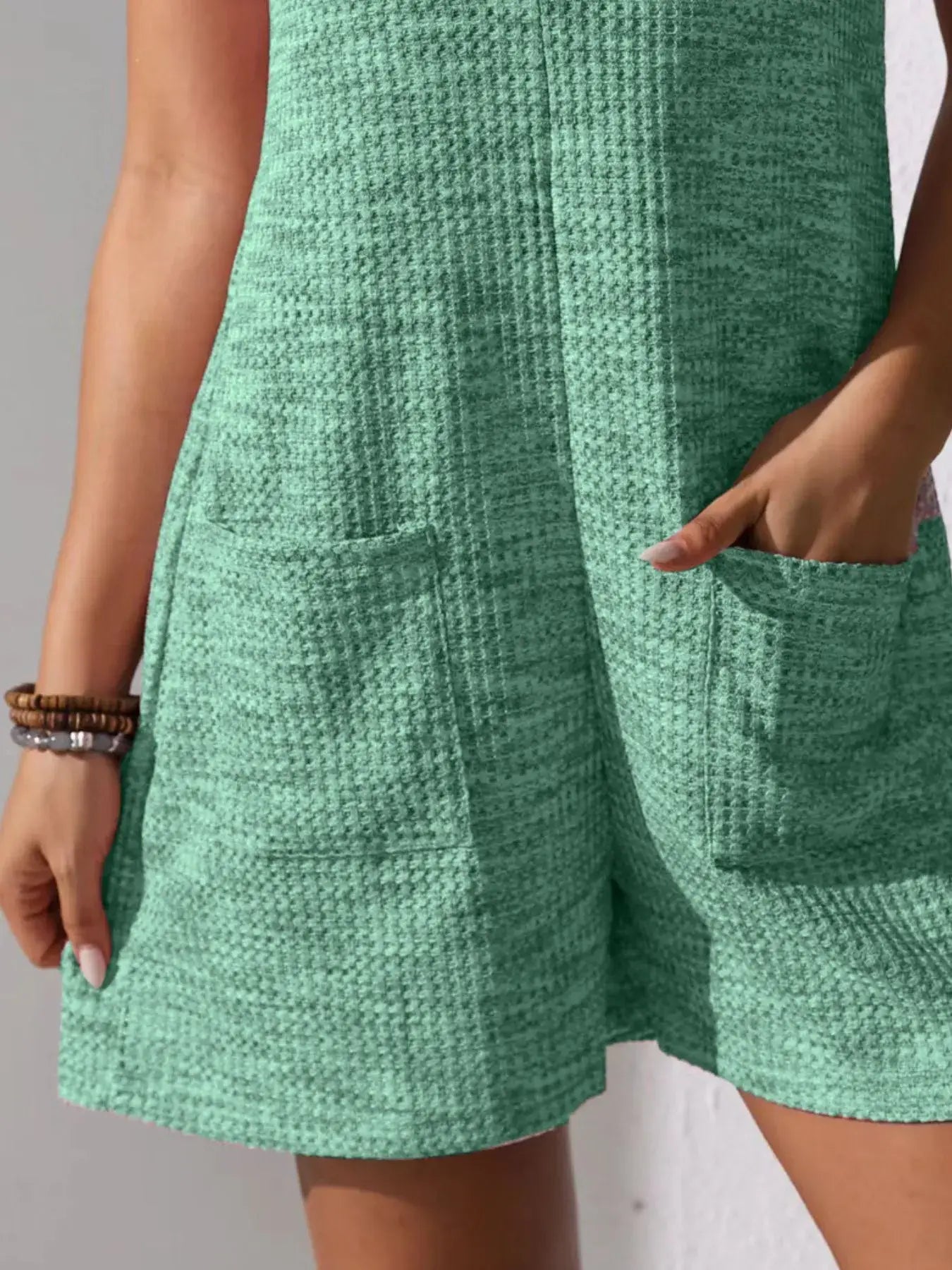 Close-up of Full Size Button Front Romper with Pockets in green, showcasing its texture and functional pockets.